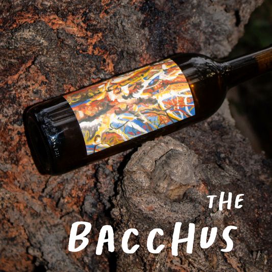 Wine bottle with colorful label on a textured stone surface, featuring 'The Bacchus' text.